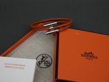une boîte orange munie d'un fermoir argenté et contenant une carte
