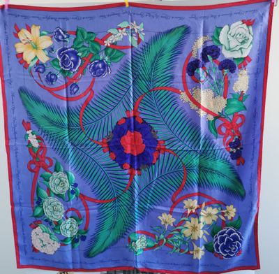 un gros plan sur une écharpe bleue ornée de fleurs et de feuilles