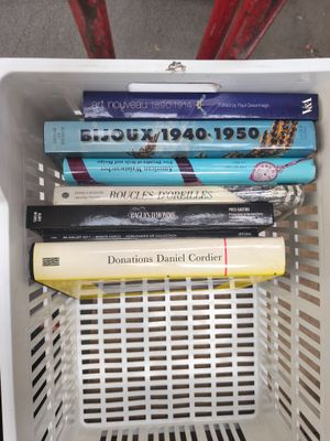 many books in a white basket on the floor