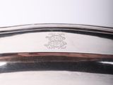 a silver tray with a silver handle on a table
