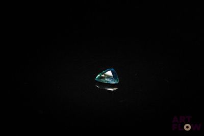 gros plan d'un diamant bleu sur une surface noire