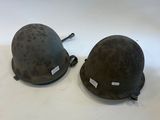 two helmets sitting on top of each other on a white surface