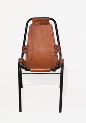 un fauteuil en cuir marron avec une structure noire et des pieds noirs