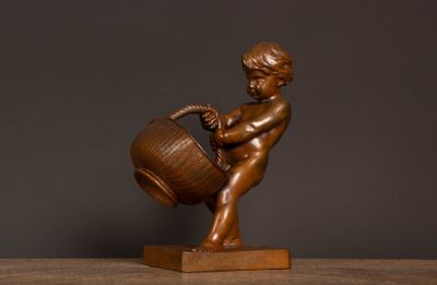 bronze statue of a boy with a bucket on a wooden base