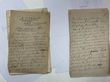 deux vieux papiers sur lesquels il y a des inscriptions, posés sur une table
