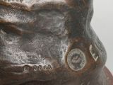 a bronze statue of a man with a hat on it ' s head