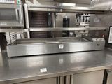 stainless steel counter top in a commercial kitchen with ovens and microwaves