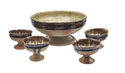 four bowls and four cups sitting on a stand