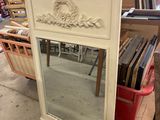 a mirror that is sitting on the floor in front of a shelf