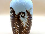 un vase bleu orné d'un motif marron et blanc