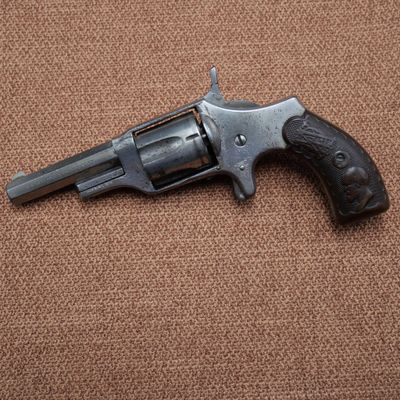 a close up of a revolver on a brown background
