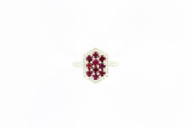 un gros plan d'une bague sertie d'un diamant rouge et blanc sur une surface blanche