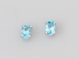 une paire de boucles d'oreilles en topaze bleue sur fond blanc