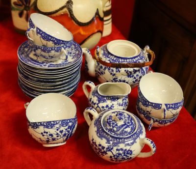 a red table with blue and white dishes and cups on it