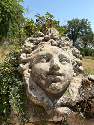 une statue en pierre représentant un homme, au milieu d'un champ