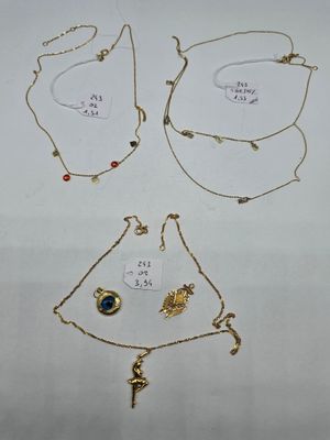 three necklaces and a bracelet are shown on a white surface