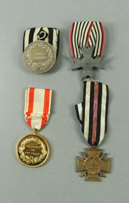three medals and a medal on a table with a gray background