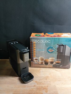 a box of coffee next to a coffee maker on a table