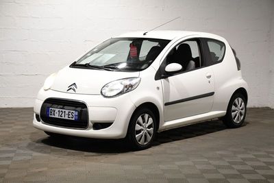 une petite voiture blanche garée dans un garage