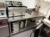 plan de travail en acier inoxydable dans une cuisine professionnelle équipée de fours et d'autres appareils électroménagers