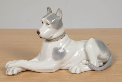 figurine en porcelaine représentant un chien couché sur une table en bois