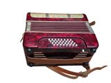 an image of a red accordion sitting on top of a wooden table