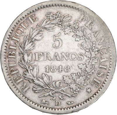a silver coin with a wreath on the front of it