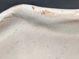 a close up of a vase with a blue flower on it