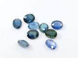 a group of blue and green gems on a white surface