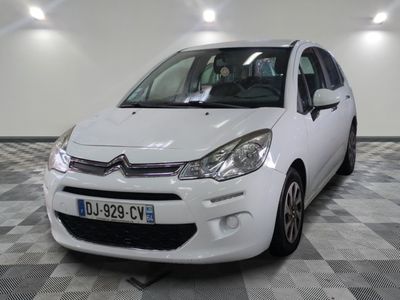 la petite voiture blanche est garée sur un carrelage à carreaux
