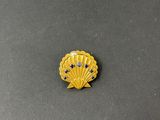 a yellow shell shaped broocher with blue stones on it