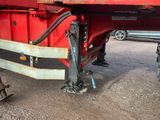 une photo d'une remorque à plateau rouge garée sur un parking
