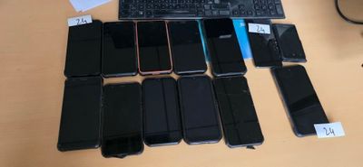 many cell phones and a keyboard on the table