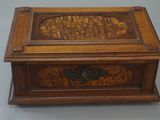 an old wooden box with carvings on it sitting on a table