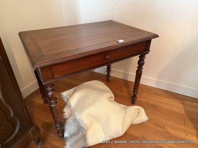 a small wooden table with a fur rug on the floor