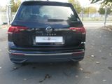 the rear end of a black volkswagen suv parked on the side of the road