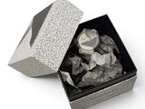 une boîte avec une montre à l'intérieur sur une surface blanche