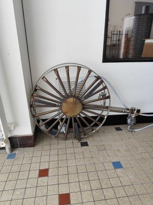 une grande roue métallique posée au sol dans une pièce