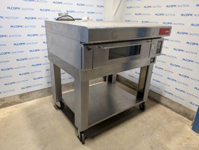 un grand four en acier inoxydable posé sur un chariot métallique