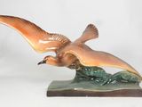 a figurine of a bird that is sitting on a table