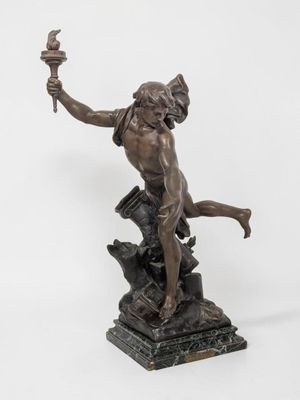 a bronze statue of a man holding a torch in his hand