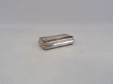 un petit briquet argenté posé sur une surface blanche