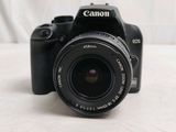 a canon camera sitting on a table with a white background