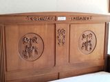 a bed with a wooden headboard with carvings on it