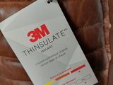 the label is attached to the back of a brown leather jacket