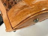 a close up of a brown leather bag on a table