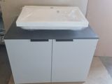 un lavabo blanc posé sur un plan de travail dans une salle de bains