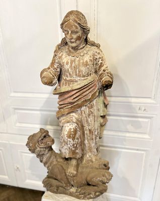 statue d'une femme accompagnée d'un chien, posée sur un socle dans une pièce
