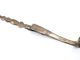 un couteau ancien en argent posé sur une surface blanche, sur fond blanc