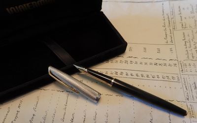 un stylo et un stylo à bille posés sur une feuille de papier